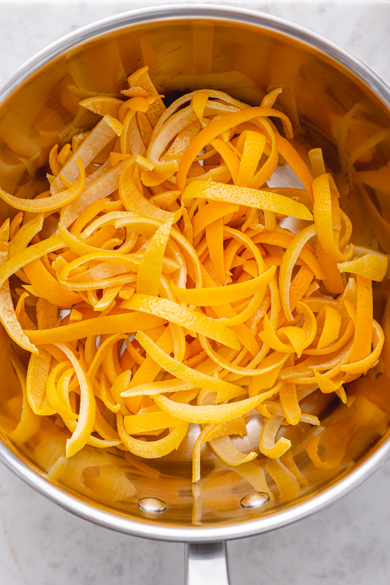 Dwukrotnie namoczone skórki cytryn i pomarańczy przed gotowaniem.